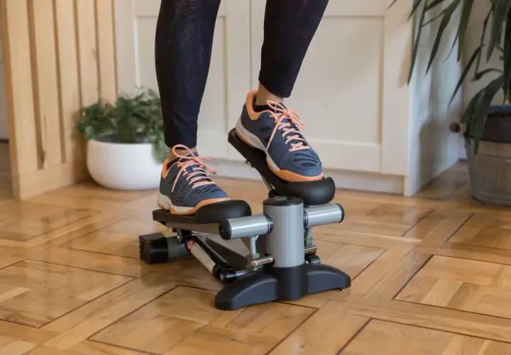 Ćwiczenia na stepperze w domu. Osoba w sportowych butach wykonuje trening, który angażuje mięśnie nóg i pośladków.